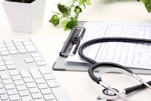 机の上にある問診票と聴診器とキーボード