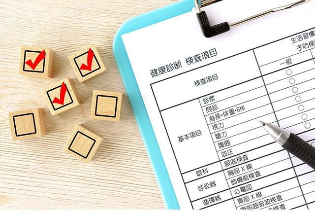 健康診断の問診票とチェックマークの積み木